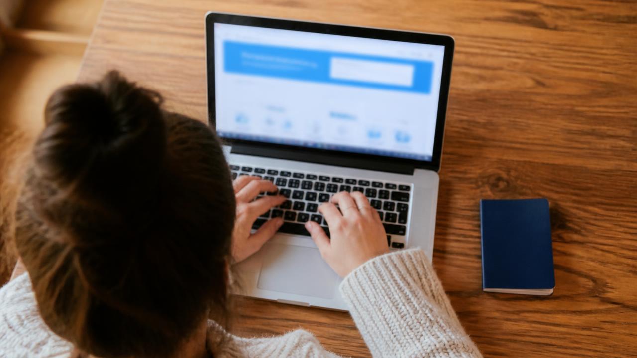 Renouvellement d'un titre de séjour en ligne sur le portail ANEF, passeport et carte de séjour posés sur un bureau